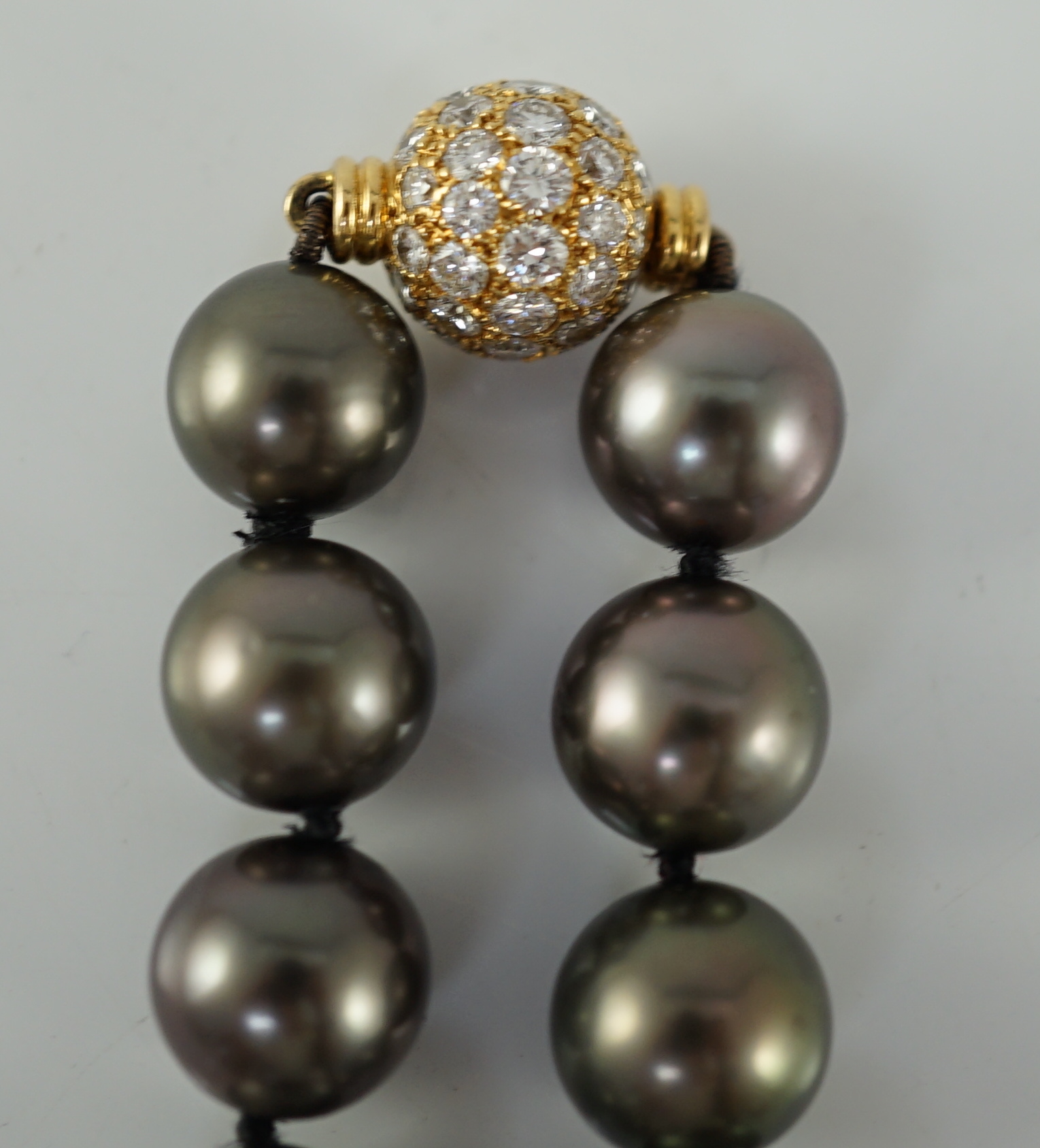 A modern Cartier single strand Tahitian pearl necklace, with 18ct gold and pave set diamond spherical clasp